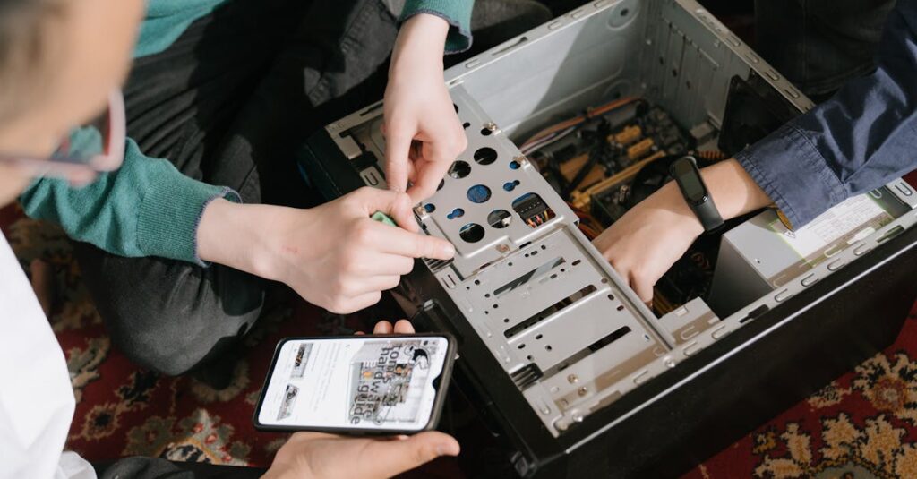 A close-up of hands fixing a computer with guidance from a mobile device.